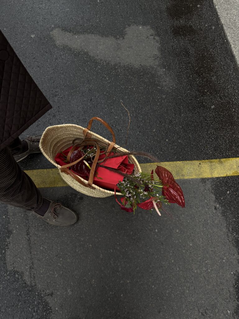 Die Blumenpause in der Mitte der Straße – rote Anthurien ragen lässig aus einem geflochtenen Korb.